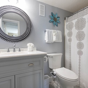 The bathroom features a stylish vanity with a large mirror, elegant decor, and fresh towels for a relaxing retreat
