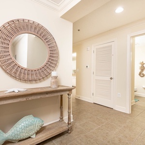 Step into a welcoming entryway featuring a stylish mirror, decorative fish accent, and a cozy console table