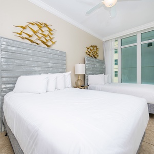 Inviting guest bedroom featuring two comfortable queen beds, stylish decor, and large windows