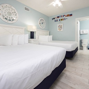 Relax in this inviting guest room with two comfortable double beds, nautical decor, and a restful vibe
