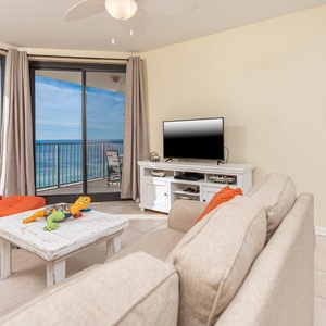 Relax in the inviting living area with colorful accents, a large TV, sofa with queen sleeper, and stunning beach views