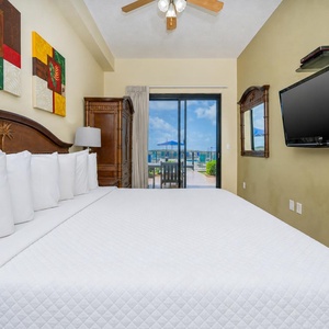 The master bedroom features a king bed, flat-screen TV, and sliding glass doors opening to a balcony with pool views