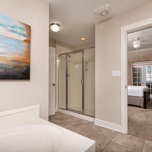 The master bath features a relaxing jetted tub, a walk-in shower, and a view into a cozy bedroom with soft, neutral tones