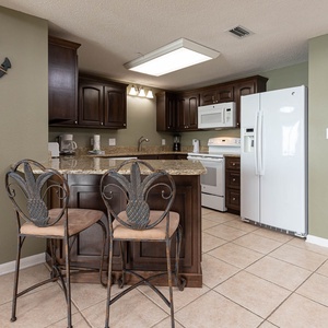 Gather around the stylish breakfast bar, perfect for enjoying meals or morning coffee in this inviting kitchen space