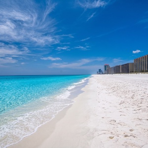 Relax on the pristine sandy beach with comfortable lounge chairs and stunning views of the sparkling water ahead