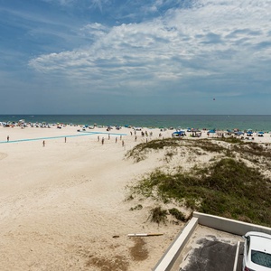 Experience a stunning beachfront view with vibrant umbrellas and sunbathers from this inviting space