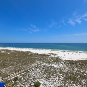 Stunning view of the beach, inviting turquoise waters, and beachgoers enjoying the sunny day