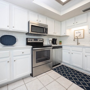 This kitchen features stainless appliances, white cabinetry, and a cozy atmosphere, perfect for your culinary adventures