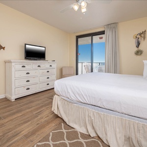 Comfortable master suite featuring a large king bed, TV, and direct access to your beachfront balcony