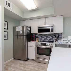 This modern kitchen features stainless steel appliances, sleek cabinetry, and a convenient layout for meal preparation