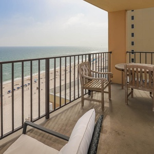 Relax on the balcony with wooden seating, enjoying the beautiful beach view and gentle sea breeze