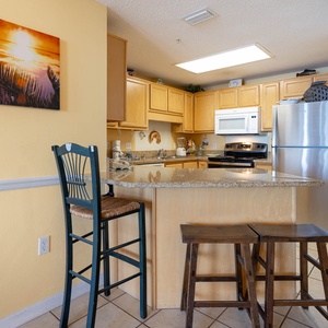 Enjoy cooking and dining at the spacious kitchen bar, complemented by warm tones and a vibrant sunset artwork