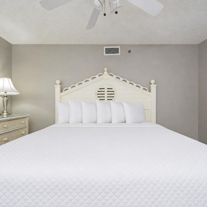Creamy tones and nautical art surround the king bed in the guest suite where you rest after beach days