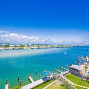 This breathtaking view showcases a serene river landscape with boats gliding by and a poolside area, perfect for relaxation