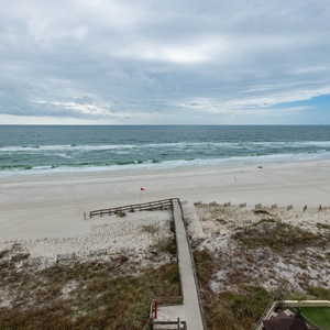 Experience breathtaking views from your balcony overlooking the sandy beach and gentle waves