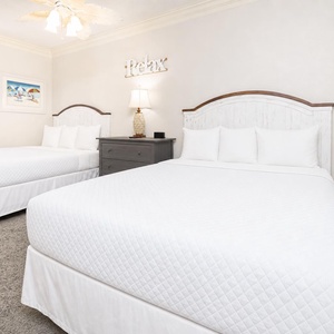 Two double beds in the guest suite invite you to unwind and dream under soft ceiling fan light