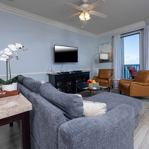Relax in the inviting living area with a plush sofa, stylish chairs, and panoramic beach views