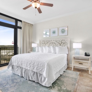 The master bedroom features a king bed, beautifully carved headboard, soft bedding, and balcony access with a stunning view
