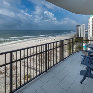 Relax on the balcony with seating, overlooking the beach and gentle waves, perfect for enjoying the view