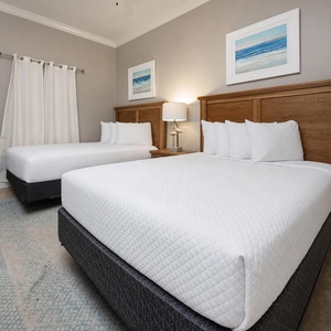Sleep peacefully in this inviting guest room with two queen beds, soft linens, and calming beach decor