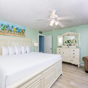 The master bedroom features a king bed, tropical decor, and a cozy seating area, perfect for relaxation after a day of fun