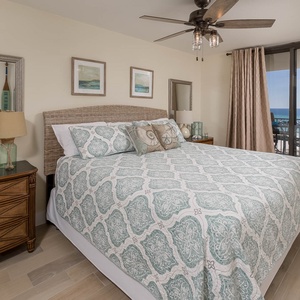 Master suite bedroom features a king bed and a view of the beach from the sliding glass door balcony