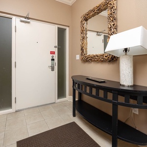 Step into this welcoming entryway featuring a stylish console table, decorative mirror, and soft lighting for a warm welcome