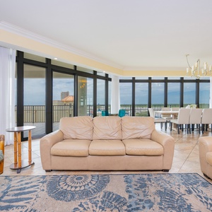 Spacious living area with plush seating and panoramic views through large windows, perfect for relaxation and gatherings