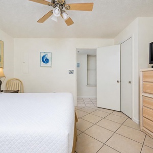 Cozy guest bedroom featuring a queen bed, ceiling fan, and beach decor for a relaxing retreat