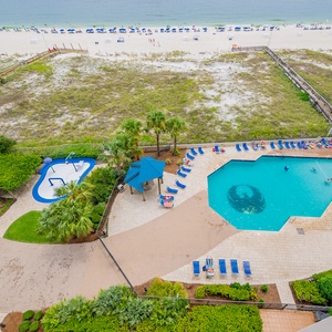 Relax by the pool surrounded by lush landscaping, with easy access to the beach and comfortable lounge chairs