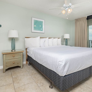 Inviting master bedroom featuring a comfortable king bed, soft lighting, and beachfront balcony access