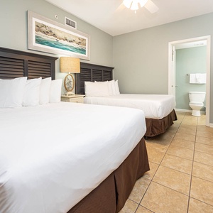 Relax in the inviting guest bedroom featuring two double beds, coastal decor, and a warm atmosphere for restful nights