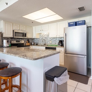 This modern kitchen features stainless appliances, granite countertops, and a cozy breakfast bar for casual dining
