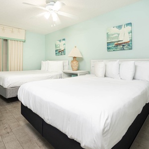 Sleep peacefully in this inviting guest room featuring two double beds, coastal decor, and a TV