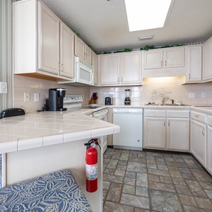 The kitchen features light cabinetry, a breakfast bar, and a Keurig coffee maker for the perfect morning brew