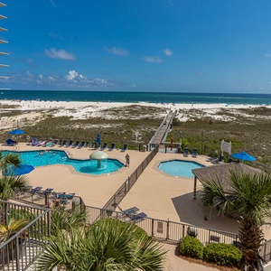 Stunning vew of the pool area featuring a fun mushroom water fountain, with the beach and Gulf visible in the background