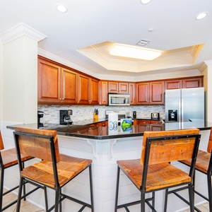 This kitchen features rich wood cabinetry, stainless appliances, and a breakfast bar perfect for casual dining