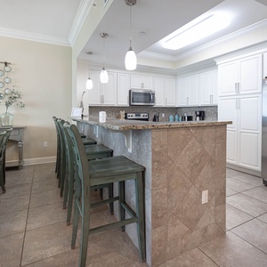 Gather around the spacious dining table or enjoy casual meals at the bar, surrounded by stylish decor