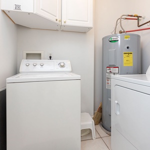 The laundry room features a washer and dryer, with ample cabinetry for storage and a clean, organized space