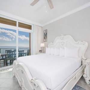Retreat to this elegant king master suite with cozy bedding and drift off to the sound of the waves from the balcony