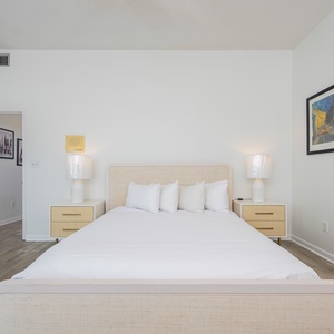 Guest bedroom featuring a cozy queen bed with plush pillows and stylish nightstands, perfect for restful stays