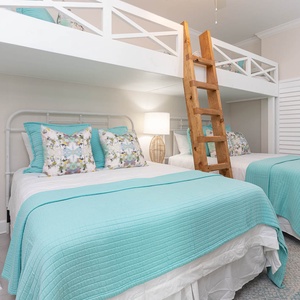 Charming guest bunk room with two lofted twin beds above two cozy queens below