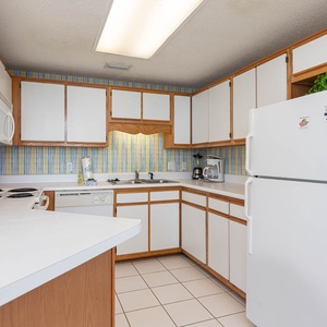 Prepare meals in the spacious kitchen, featuring ample counter space, and cheerful striped wallpaper