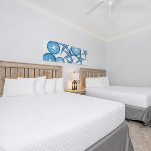 Guest bedroom featuring two cozy queen beds and beach-inspired decor for a relaxing getaway