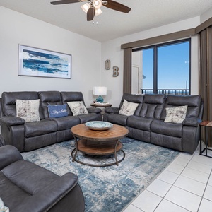 Unwind in the spacious living area, featuring plush seating and views of the beach and inviting outdoor pool