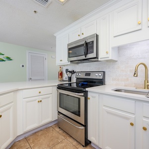 Cook and gather in this inviting kitchen, featuring sleek appliances and charming coastal decor for your culinary delights