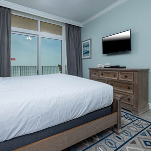 Relax in this serene master suite featuring a king bed, stylish decor, and stunning balcony views