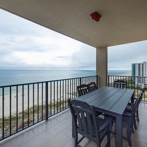 Dine al fresco at the spacious table on the balcony, enjoying refreshing views of the tranquil waters and beach