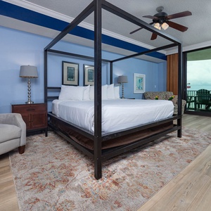 Unwind in the master suite with a cozy king bed, seating area, and access to the beachfront balcony
