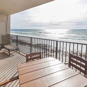 Savor the fresh air from your balcony, featuring a table and chairs with views of the tranquil waters and shoreline